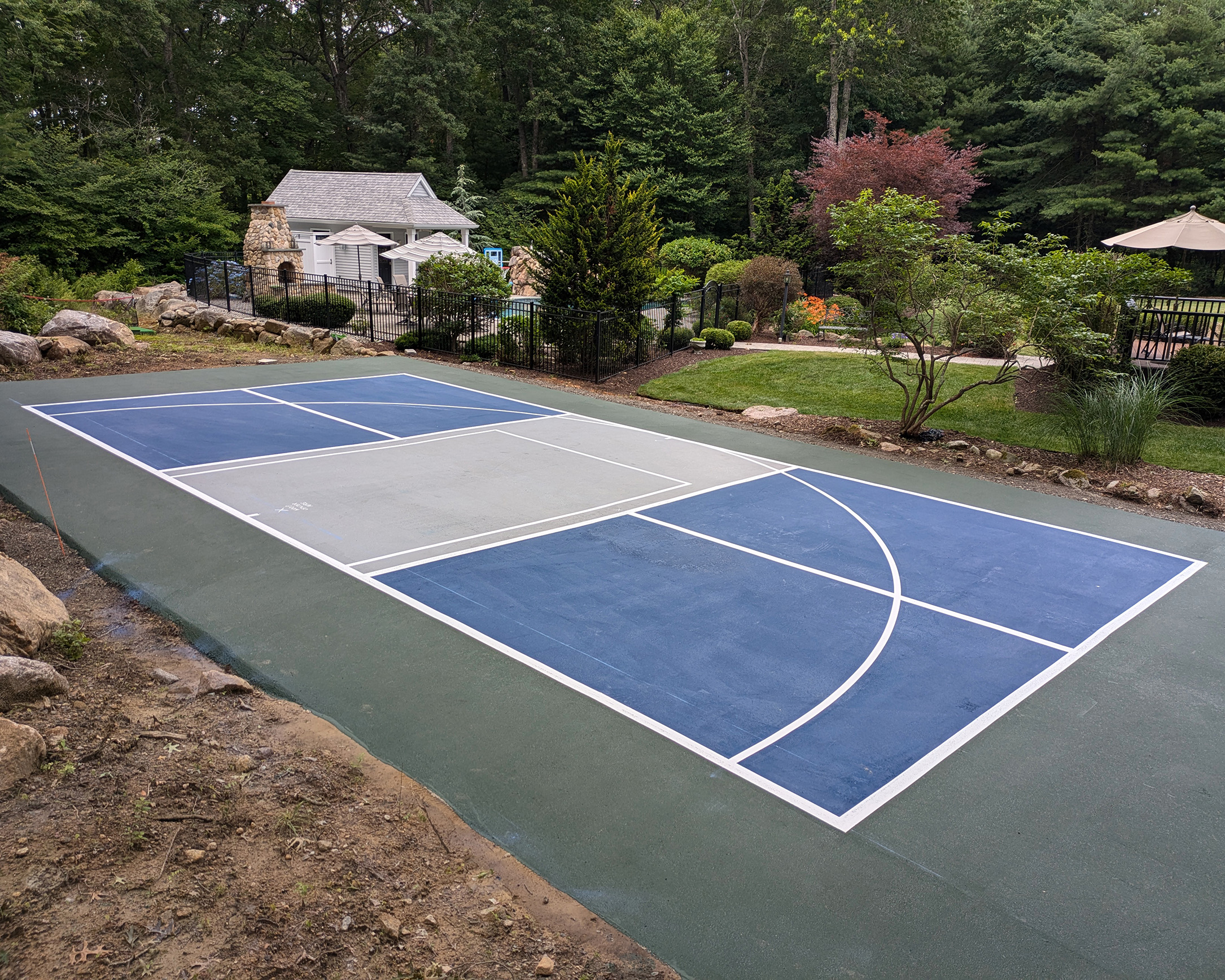 a painted sport court that is a combination of pickleball and basketball done by 1-800-Striper of Providence