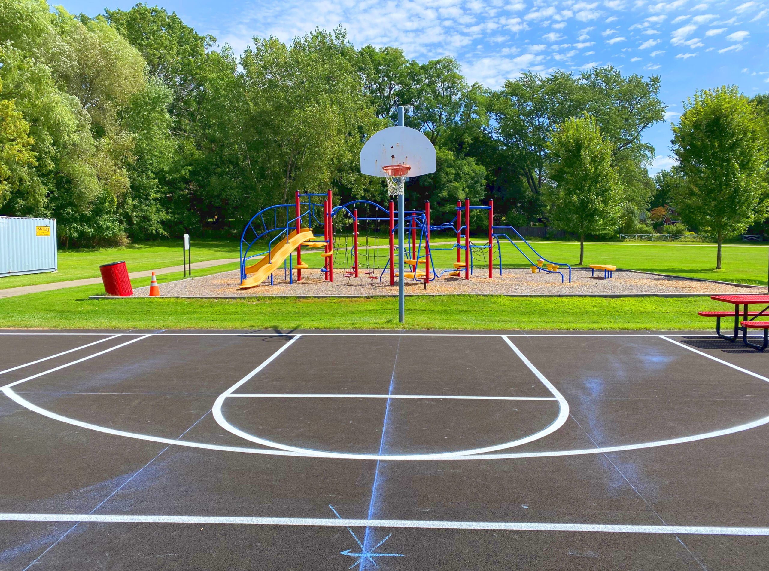 White basketball court painting in front of a playground in Bellevue, WA