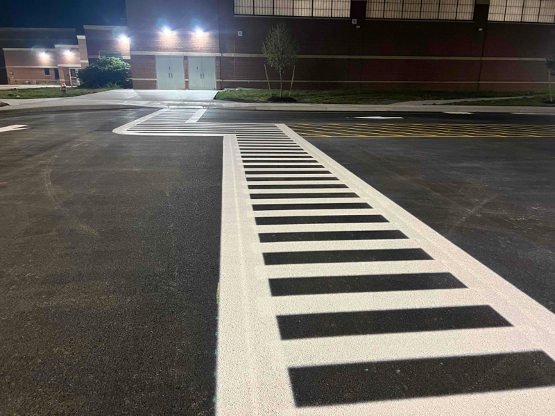 parking lot striping in northgate, seattle on pressure washed asphalt. White cross walk with yellow hashed space