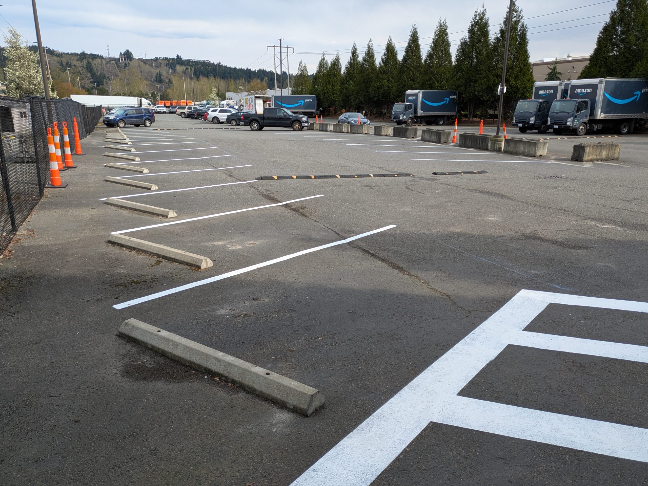 Freshly painted white parking lot striping at an Amazon facility in Renton, WA, with angled stalls and clear lane markings designed for improved traffic flow and organization.