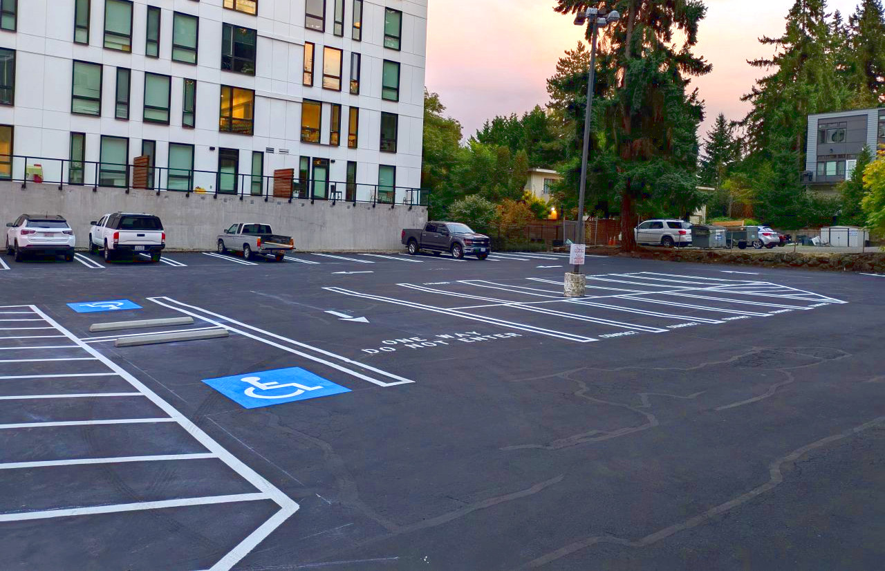 White parking lot striping with blue handicap stalls and white lettering in Marysville, WA